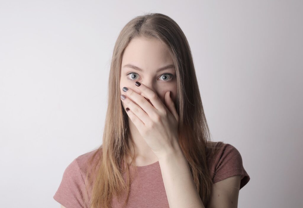 a young woman covering her mouth because of hre problem teeth