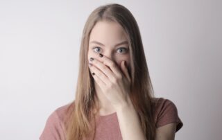 a young woman covering her mouth because of hre problem teeth